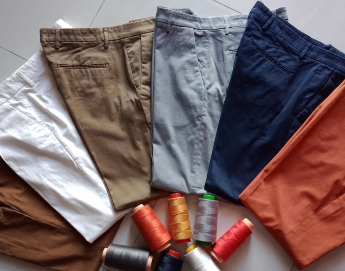 Pantaloni finiti in diversi colori con rocchetti di filo
